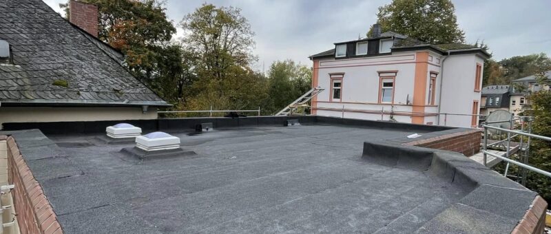 Kleines Flachdach mit beschieferter Bitumenbahn und Mauerwerksrand
